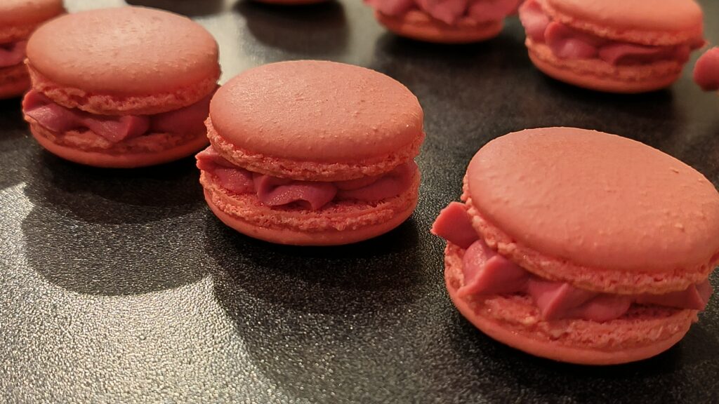 Handcrafted pink French macarons with a creamy filling, freshly made by Box of Nom.
