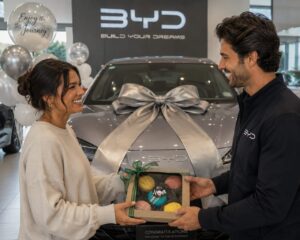 Car dealership handing over a new vehicle with a Box of Nom macaron gift, celebrating a customer's new car purchase.